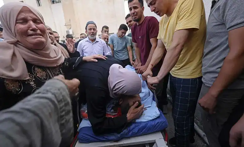 A woman mourns as others gather around in a scene of grief in the West Bank.