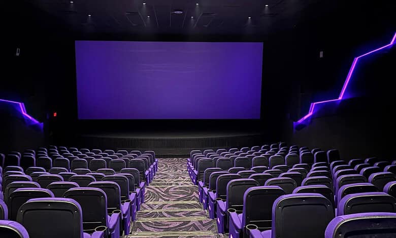 Empty modern cinema theatre with purple lighting and large screen in Hyderabad.