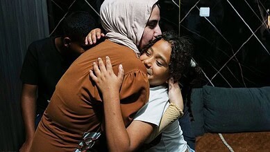 Family members sharing a heartfelt hug, expressing love and support in a cozy setting.