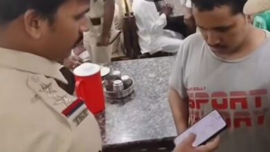 Chaderghat police officials check phones in a cafe in Hyderabad.