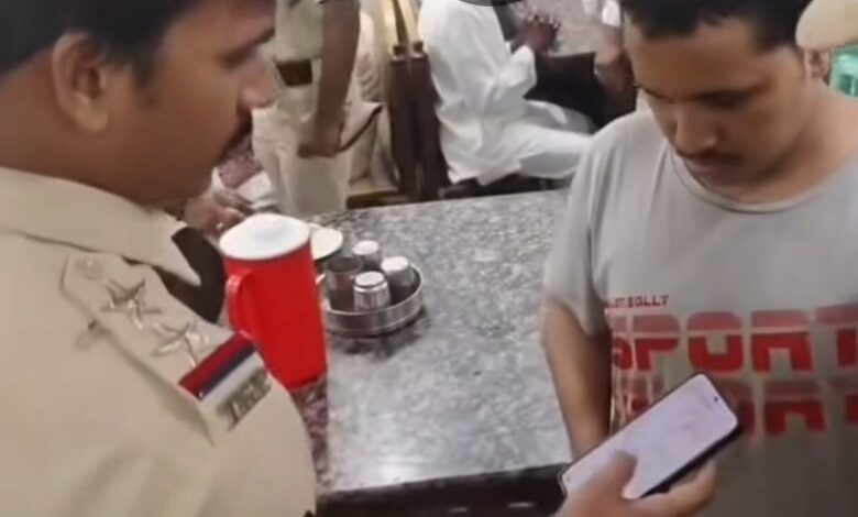 Chaderghat police officials check phones in a cafe in Hyderabad.
