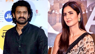 Katrina Kaif and Prabhas at a promotional event, smiling and posing for the camera.