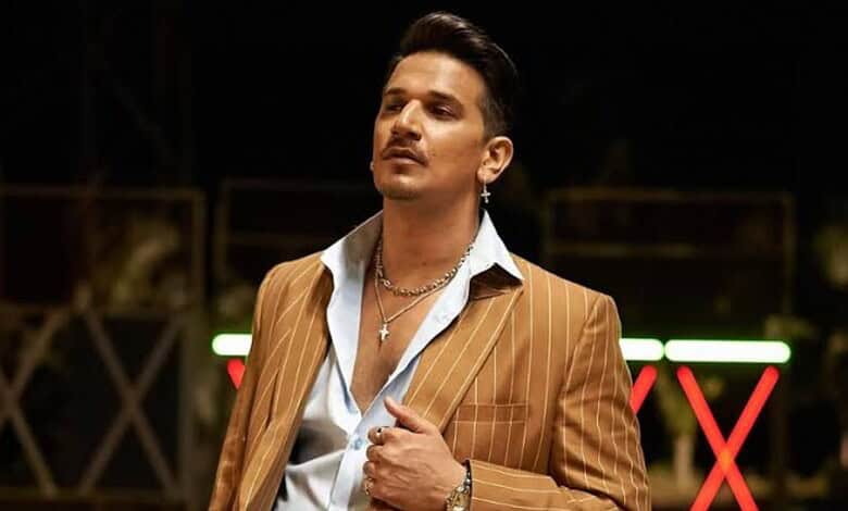 Prince Narula in a brown pinstripe suit during a public event or interview.
