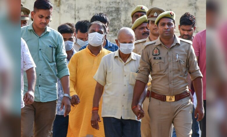 Police personnel escort accused to a court in connection with the alleged embezzlement of Ram Temple donation funds, in Ayodhya, Friday, June 26, 2026. (PTI Photo)