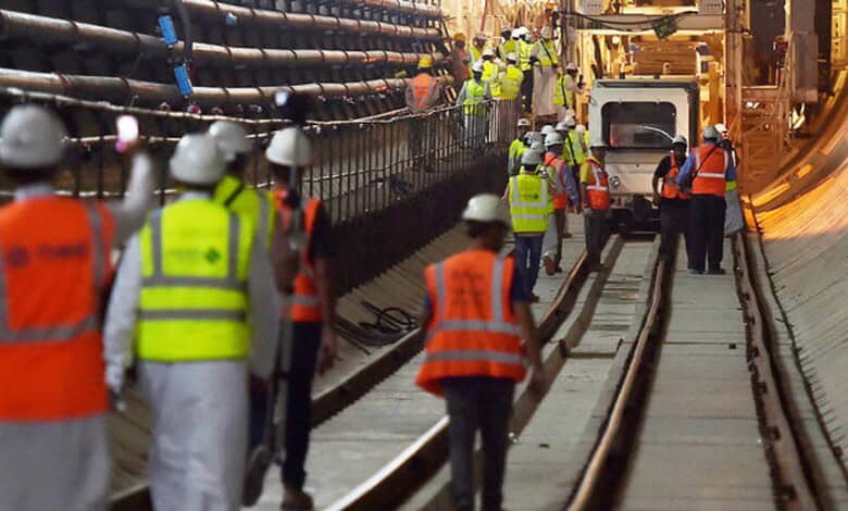 Engineers and workers in safety gear working on a construction site in a tunnel.