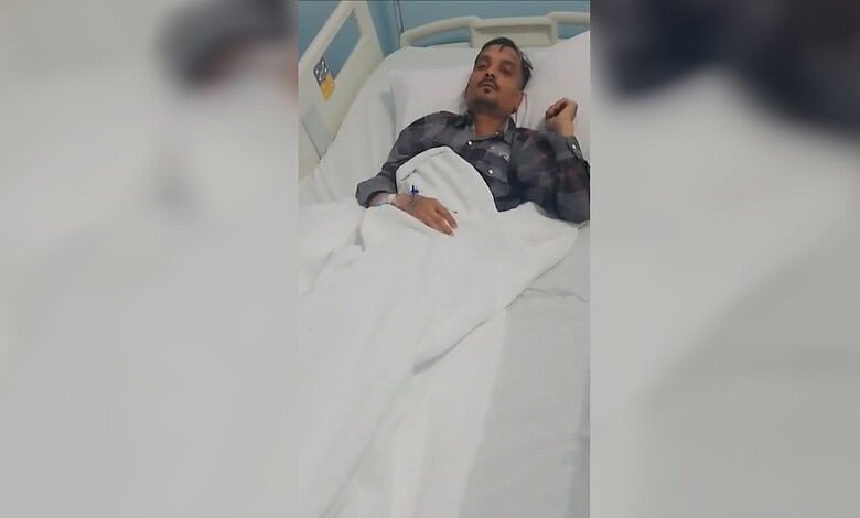 Woman lying in hospital bed, looking distressed, with a bandage on her hand, in a medical setting.