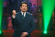 Shekhar Suman hosting his late night show with vibrant green stage lighting.