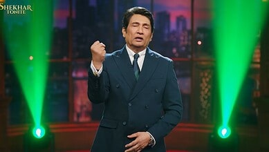 Shekhar Suman hosting his late night show with vibrant green stage lighting.