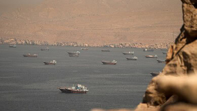 Cargo vessels transit the Strait of Hormuz, viewed from Musandam, Oman, on June 18, 2026.
