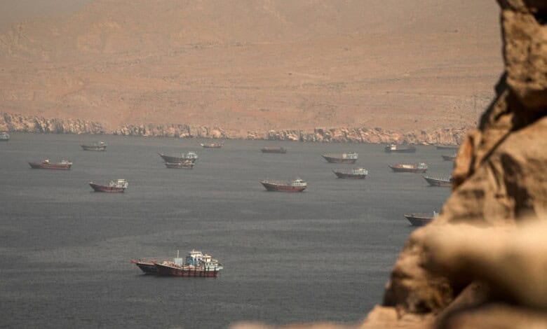 Cargo vessels transit the Strait of Hormuz, viewed from Musandam, Oman, on June 18, 2026.