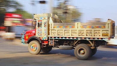 Moving truck on a busy road in South India during daytime.