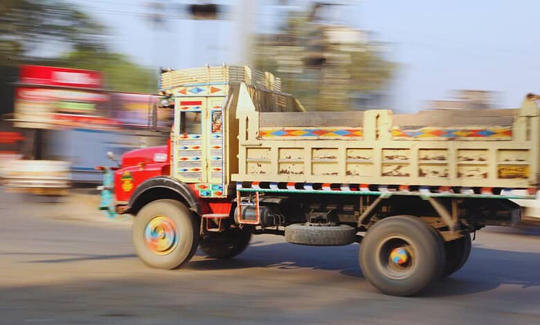 Moving truck on a busy road in South India during daytime.