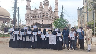 Students protesting in Hyderabad after exam results, holding placards demanding justice.