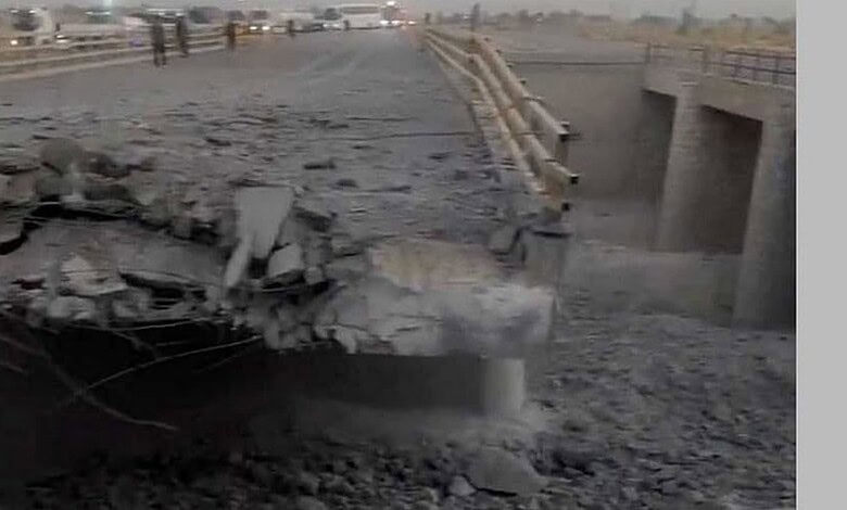 Collapsed section of a bridge with debris and broken concrete.