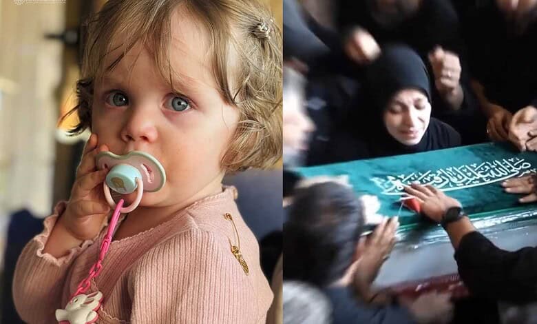 Child with blue eyes and pacifier next to a funeral procession with mourners in black.