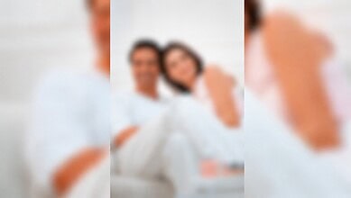 Blurred image of a couple celebrating a wedding, with a man and woman smiling.
