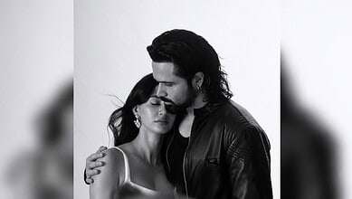 Black and white image of a man and woman embracing, with the man gently resting his head on the woman's.