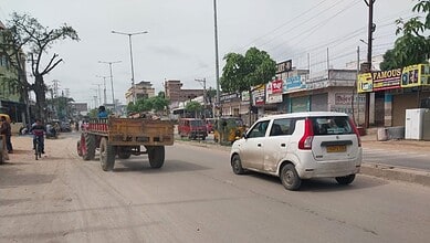 Poorly maintained Barkas-Pahadishareef road with potholes and low lighting, vehicles navigating unevenly.