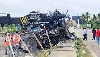 Wreckage of a bus involved in a crash on Bengaluru-Mysuru Expressway, with debris scattered.
