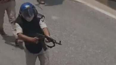 Bihar cop wields an AK-47 during student protests