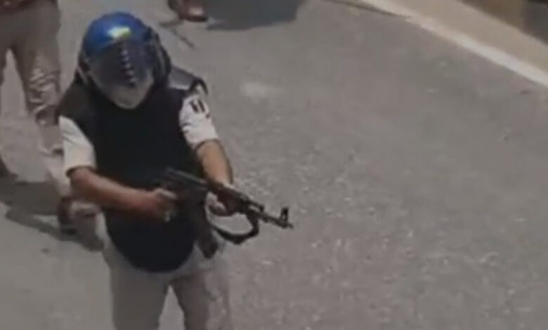 Bihar cop wields an AK-47 during student protests