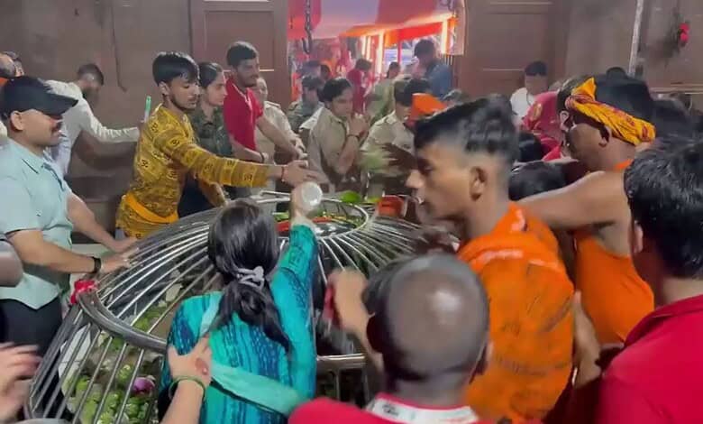 Crowd gathered around a fallen metal structure during a temple stampede in Bihar.