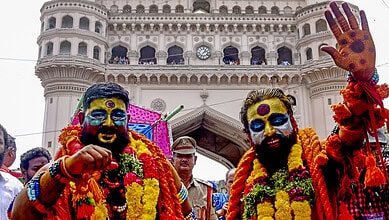 Two men with colourful face paint and flower garlands celebrate at Hyderabad Old City Bonalu festival.Hyderabad Old City Bonalu festival to conclude today