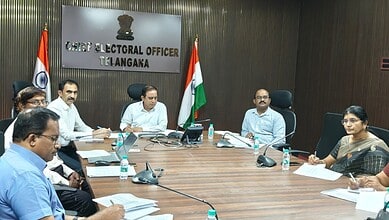 Election officials and staff seated at a conference table during a meeting at Telangana's Chief Electoral.