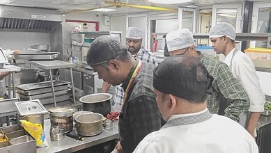Kitchen staff inspecting food safety standards at a Bengaluru restaurant during an official check.