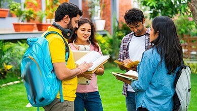 Group of diverse students studying outdoors in a lush green campus setting.