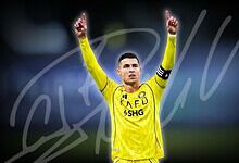 Cristiano Ronaldo in yellow football kit celebrating with arms raised during match.