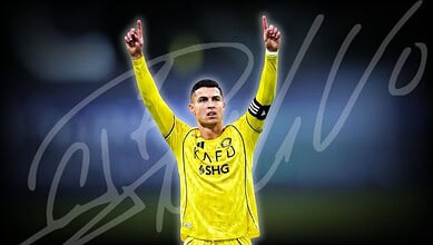 Cristiano Ronaldo in yellow football kit celebrating with arms raised during match.