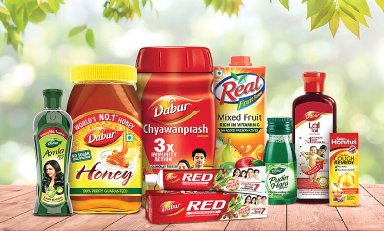 Assorted Dabur food products including honey, chyawanprash, and fruit juice on a wooden surface.
