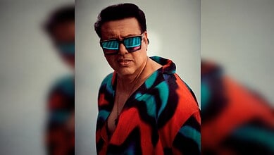 Govinda wearing a vibrant jacket and sunglasses, posing for a photo in a casual setting.