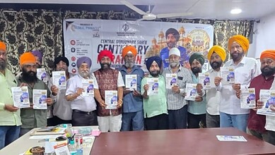 Group of people holding flyers during Gowliguda Gurudwara's centenary event in Hyderabad.
