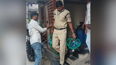 Police officer seizes illegal motors during crackdown in Bapunagar, India.