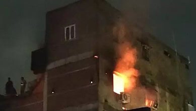 Fire erupts from a building in Old City's Fateh Darwaza at night, thick smoke rising.