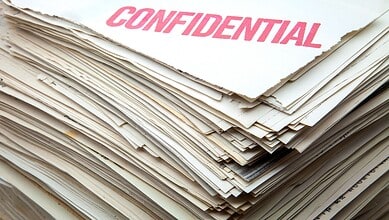 Confidential documents with a pink 'CONFIDENTIAL' stamp on top.