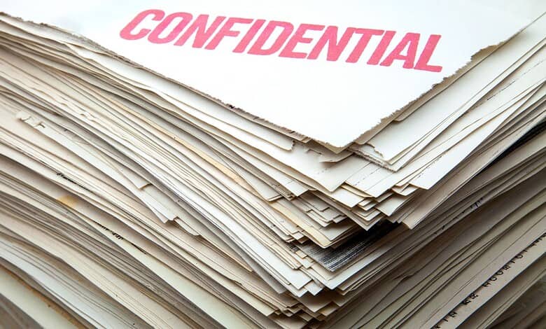 Confidential documents with a pink 'CONFIDENTIAL' stamp on top.