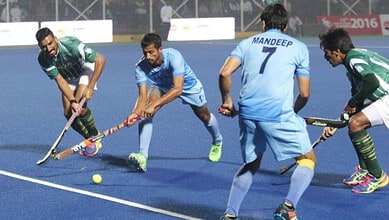 India and Pakistan field hockey players compete fiercely during a match.