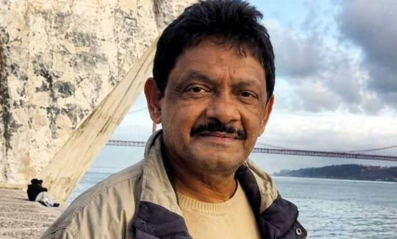 Shakeel Noorani, filmmaker, near a bridge with water in the background, during daytime.