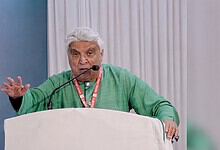 Javed Akhtar speaking passionately at a public event with a microphone.