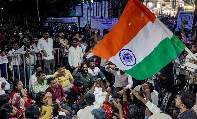 Protesters holding Indian flag during Jharkhand exam protest demonstration.