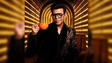 Aamir Khan in stylish black outfit holding an orange cup on Koffee With Karan 9 set.