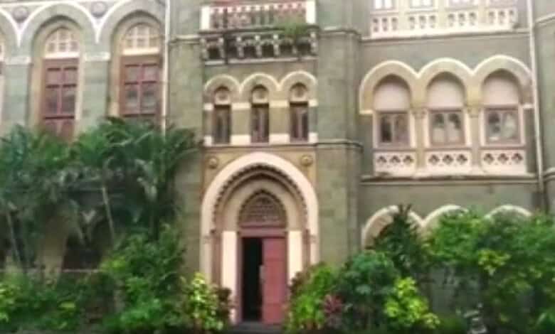 Exterior view of a historic Mumbai library with lush greenery and ornate architecture.