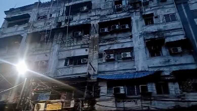 Burnt building facade after fire in Kolkata hotel, with damaged windows and charred exterior.