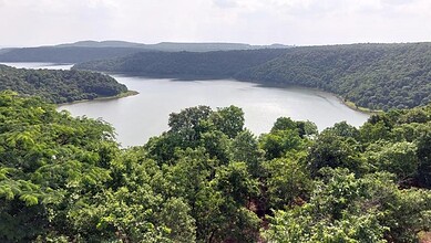 Scenic view of a wildlife sanctuary with a lake surrounded by lush green forests in Hyderabad.