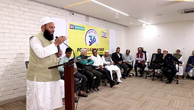 Religious leader speaking at a seminar with an audience in a modern conference room.
