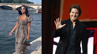 Mallika Sherawat in a leopard print dress by the river, wearing sunglasses and walking along the water.