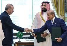 Leaders from India and Saudi Arabia shake hands during a formal meeting.